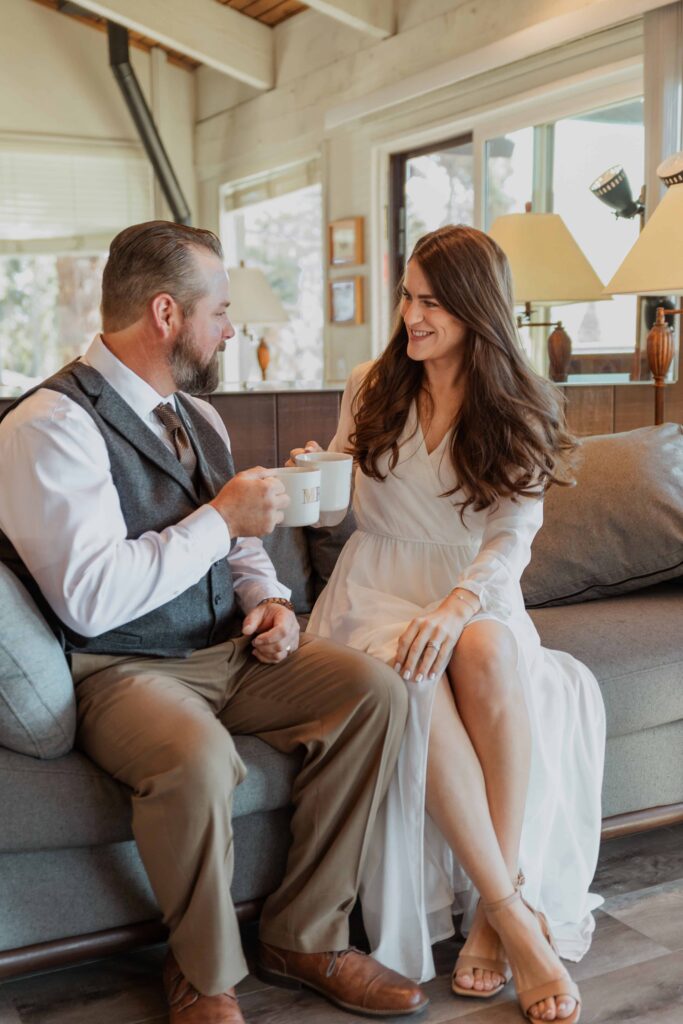 A couple enjoys a cup of coffee together in their wedding attire. 