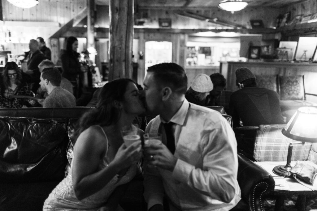 A couple toasting drinks on their elopement day at Tamarack Restaurant, Mammoth Lakes, CA.