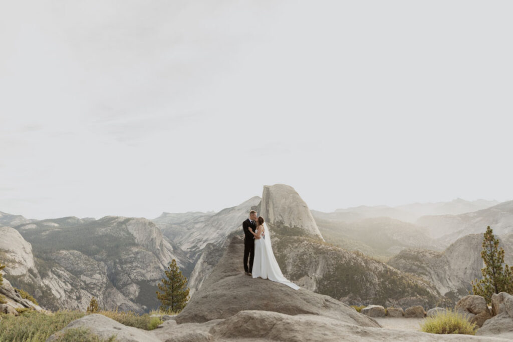 A couple kisses at Glacier Point on their wedding day. 