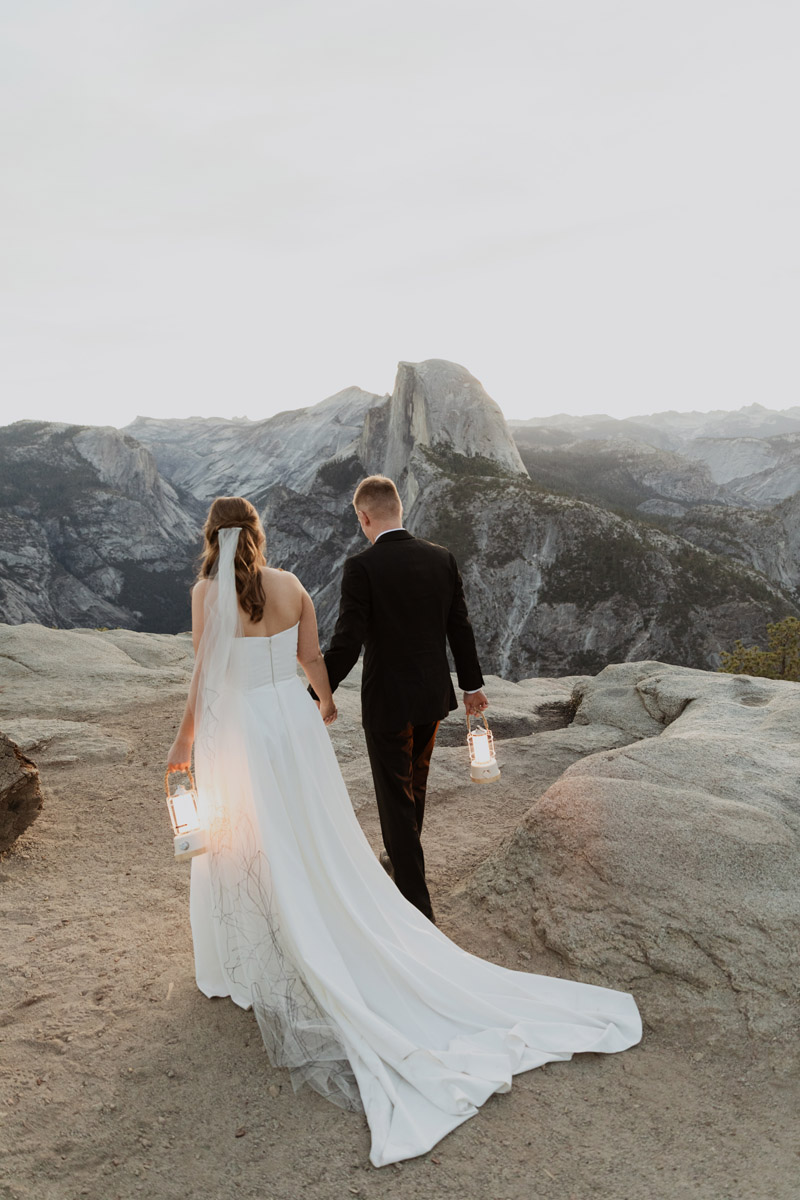 A newly married couple walks at Glacier Point at sunrise.